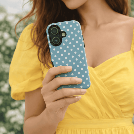 A girl holding a Dusty Blue Polka iPhone 17 tough case