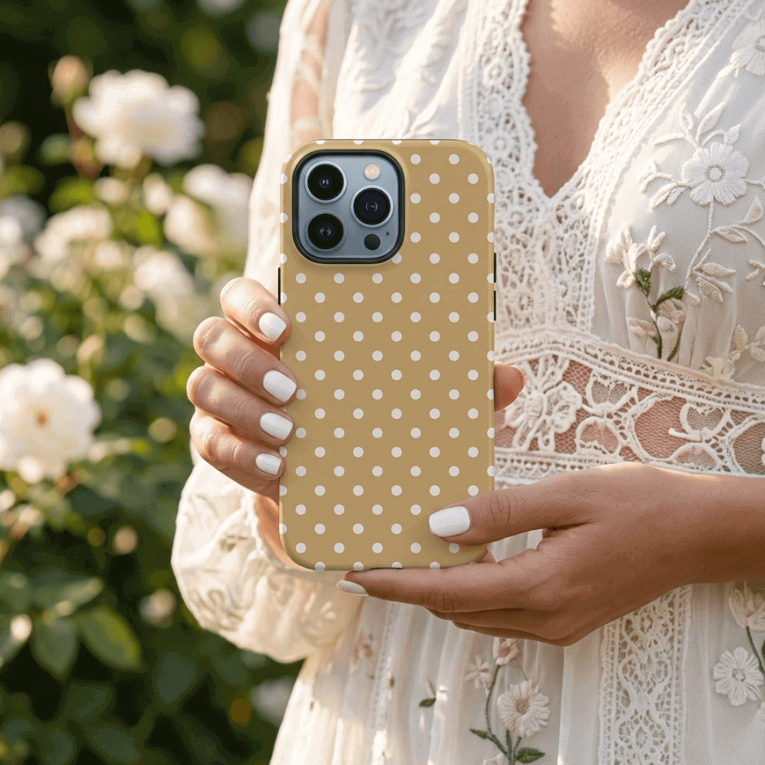 Girl holding a phone with a latte luxe polka dot case