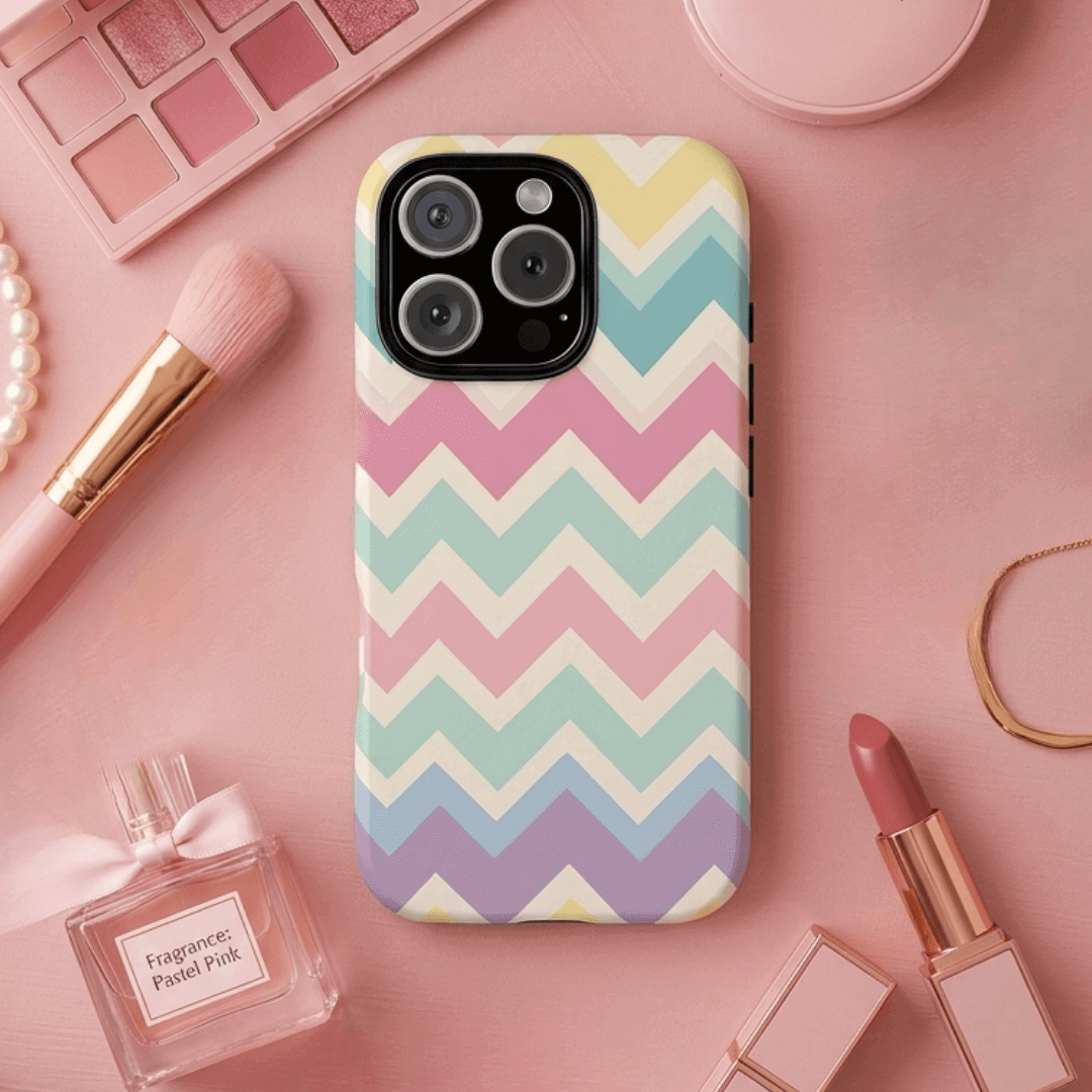 iPhone 16 Pro tough phone case with pastel chevron zigzag pattern on a pink surface with makeup items
