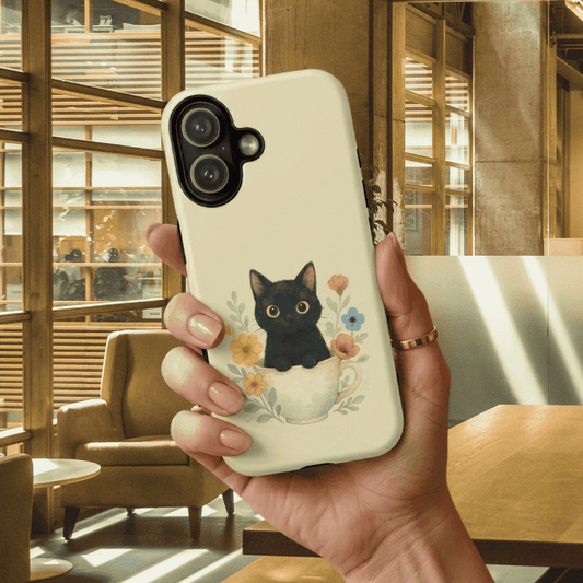 Cute black cat iPhone tough phone case with a held by a hand in a sunlit room