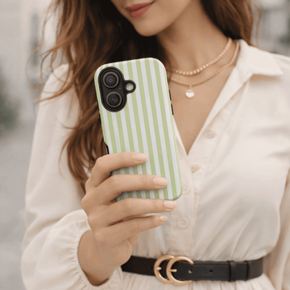 A lady holding a  iPhone 17 with a green and white striped case